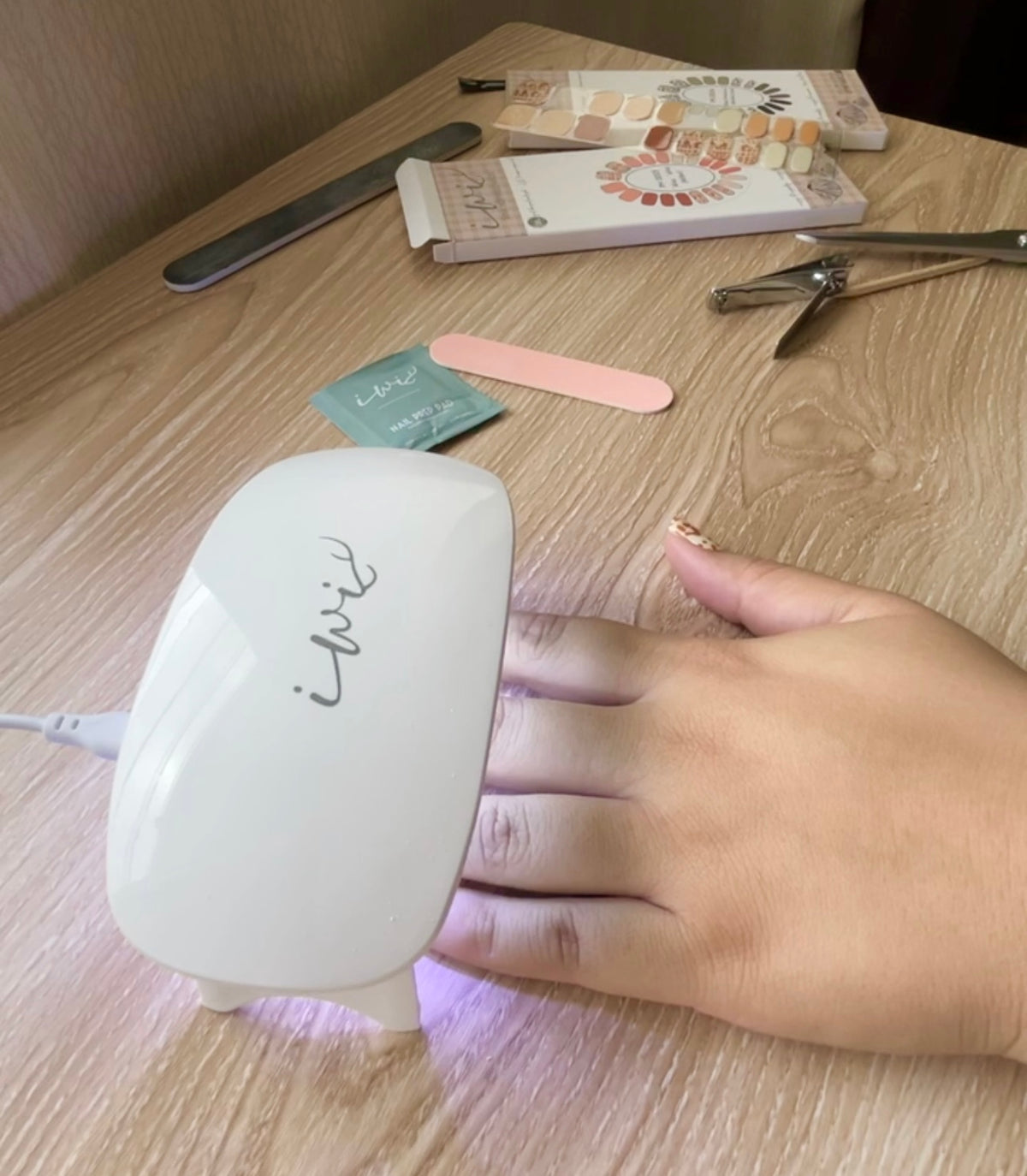 Pop-Up Mākeke - Iwi Nails - Gel Nail Strips - Pūpū Pōniuniu 1 (Hebrew Cone) - Gel Lamp in Use